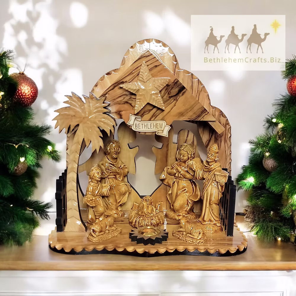 Complete olive-wood nativity scene beneath an ornate carved stable