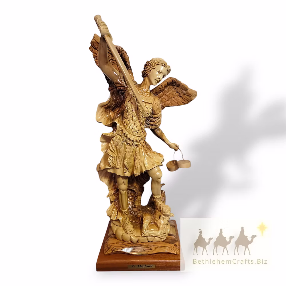 Carved Saint Michael figurine with outstretched wings, a sword, and scales